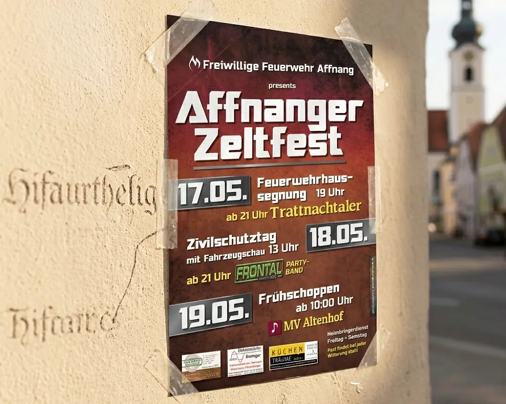 Wetterfester Druck eines Veranstaltungsplakats im Außeneinsatz an einer Hauswand.