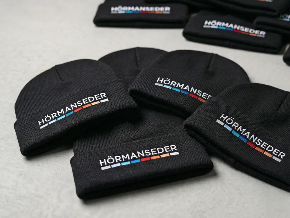 Mehrfarbig bestickte Mützen als Fan-Fashion und hochwertiges Give-Away für Kunden.
